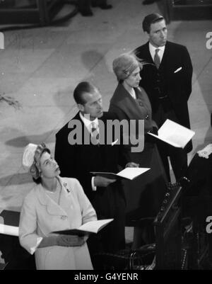 Königin Elizabeth II. Schaut nach oben und andere Mitglieder der Königlichen Partei stehen vor der Westtür, als der Bischof von Guildford während der Weihe der neuen Kathedrale von Guildford den Eintritt verlangt. Mit ihr sind der Herzog von Edinburgh, Prinzessin Margaret und Antony Armstrong-Jones. Stockfoto