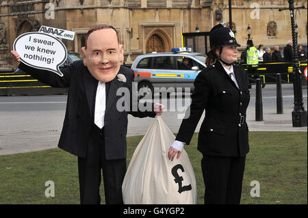 Demonstranten mit James-Murdoch-Kopf und Polizeiuniform demonstrieren im Rahmen einer Kampagne der Organisation Avaaz gegen das Murdoch-Medienreich vor dem Oberhaus. Stockfoto