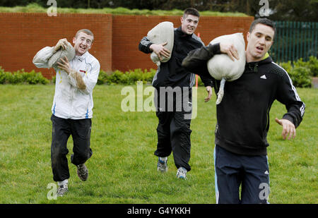 Irlands Paddy Barnes (vorne links), Joe ward (hinten links) und David Oliver Joyce tragen Sandsäcke während der Ausdauer der irischen Streitkräfte und des Team-Building-Angriffs im Curragh Army Camp, Curragh. Stockfoto