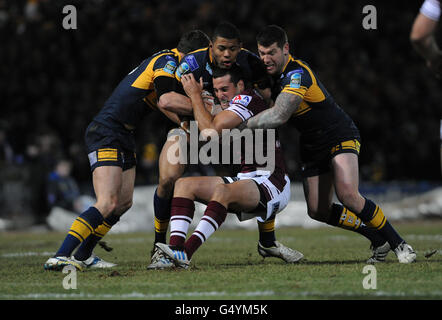 Rugby League - die Heinz Big Soup World Cup Challenge 2012 - Leeds Rhinos gegen Manly Sea Eagles - Headingley Carnegie. Manly Sea Eagles' Michael Oldfield (Mitte) wird von der Verteidigung der Leeds Rhinos während des Spiels der World Club Challenge in Headingley, Leeds, gehalten. Stockfoto