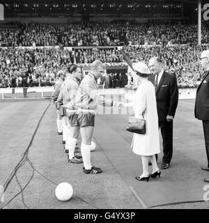 Die Königin schüttelte sich die Hände mit dem englischen Kapitän Bobby Moore, als das England-Team und ihre Gegner Uruguay ihr auf dem Feld im Wembley Stadium in London vorgestellt wurden, nachdem sie das erste Weltcup-Spiel des Turniers eröffnet hatte Stockfoto