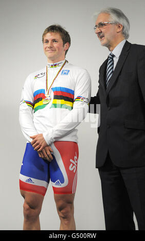 Der britische Jason Kenny erhält sein Regenbogentrikot und die Goldmedaille vom Präsidenten von British Cycling Brian Cookson, da er zum Sprint-Weltmeister wird, nachdem der französische Gregory Bauge während eines Vorweistages für den UCI Track Cycling World Cup im Velodrome in der wegen Verstößen gegen Drogentests suspendiert wurde Olympic Park, London. Stockfoto