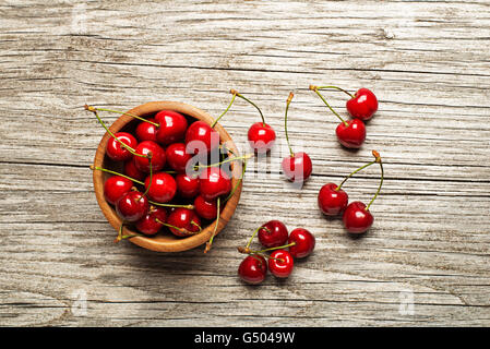Frische Kirschen in einer Schüssel auf Holztisch. Stockfoto