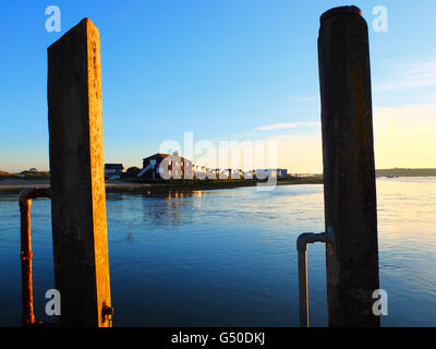 Das Schwarze Haus am Mudeford Quay, Dorset, Beiträge dazwischen Hafen in der Nähe von sunset Stockfoto