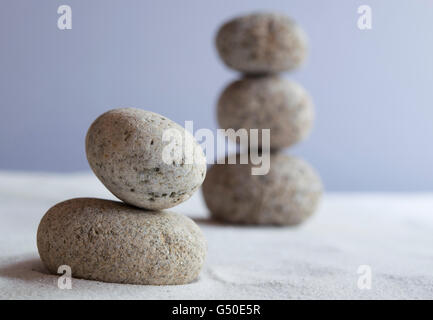 Meditative Steinen im Gleichgewicht auf weißem sand Stockfoto