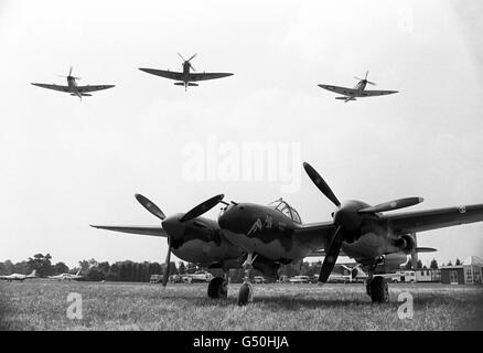 Drei Spitfire fliegen über „Miss Bhaving“, einem Lockheed P38 Lightning. Diese alten Flugzeuge aus dem Zweiten Weltkrieg werden auf der Biggin Hill International Air Fair ausgestellt Stockfoto