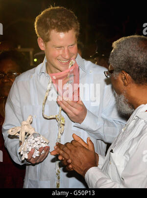 Prinz Harry probiert eine Maske an, während er an einem traditionellen Tanz während eines Spaziergehens auf einer „Blockparty“ im neu benannten Queen Elizabeth II Boulevard in der Hauptstadt Belmopan, Belize, Mittelamerika, teilnimmt. Der Prinz besucht Belize im Rahmen einer Diamond Jubilee Tour, wo er Belize, die Bahamas, Jamaika und Brasilien als Vertreter von Königin Elizabeth II. Besuchen wird Stockfoto