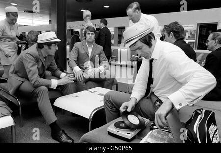 Die England Mannschaft am Flughafen Heathrow in London vor Mexiko und dem Weltcup-Turnier. Im Bild ist Jeff Astle, der auf dem tragbaren Plattenspieler eine Platte spielt, während er mit Emlyn Hughes (links) und Geoff Hurst auf ihre Abreise wartet. Mit ihrem bei Pye Records veröffentlichten Song Back Home erreicht England derzeit den Spitzenplatz in den Charts. Stockfoto