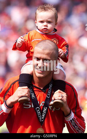 David Beckham von Manchester United trägt seinen Sohn Brooklyn auf den Schultern, während seine Mannschaft nach ihrem Spiel gegen Tottenham Hotspur zum FA Carling Premiership Champions gekrönt wird. * ...in Old Trafford, Manchester. Endergebnis: Manchester United 3, Tottenham Hotspur 1. 22/02/02 David und Victoria Beckham gaben bekannt, dass sie ihr zweites Kind im September erwarten. Stockfoto