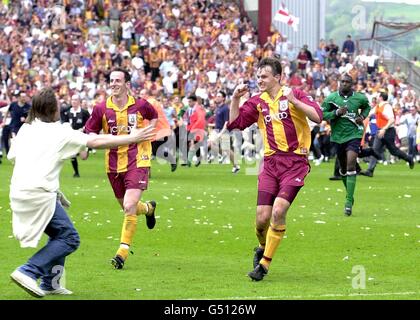 Bradford-Torschütze David Wetherall (rechts) läuft nach dem Ende des Fußballspiels neben Teamkollege Andy O'Brien ab und wird von einem Bradford-Fan begrüßt. * Wetherall's Tor gegen Liverpool hielt Bradford in der Premiership während des FA Carling Premiership Fußballspiels in Valley Parade, Bradford. Endergebnis: Bradford City 1 Liverpool 0. Stockfoto