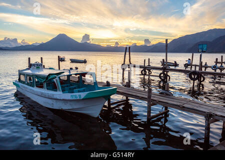 Ein Wasser-Taxi sitzt angedockten in Panajachel am Abend den Sonnenuntergang über dem Lago de Atitlan, eine vulkanische Krater-See in Guatemala Stockfoto