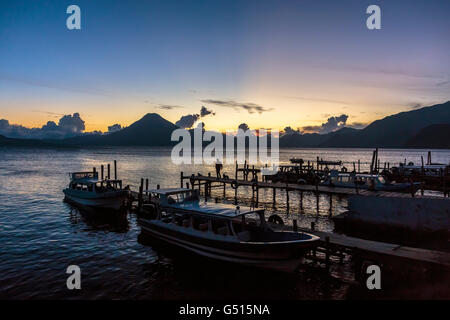 Die Sonne geht über Lago de Atitlan in Guatemala, und Touristen und Einheimische zu sammeln, an den Docks in Panajachel, Dämmerung begleichen zu sehen. Stockfoto