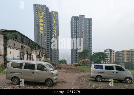 China, Chongqing, zwei Minivans vor den Wohnhäusern Stockfoto