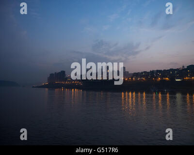 China, Chongqing, Flusskreuzfahrt auf dem Yangtze Fluss, beleuchtete Stadt von Zhongxian über den Jangtse-Fluss Stockfoto