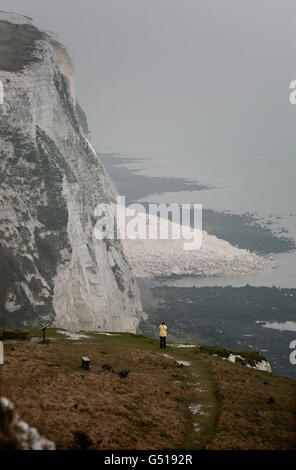 Eine Dame blickt auf den Steinhaufen, der am Strand zwischen den Langdon Cliffs und dem Leuchtturm von South Foreland hinterlassen wurde, nachdem ein großer Teil der berühmten Weißen Klippen von Dover am vergangenen Freitag in den Ärmelkanal eingestürzt war. Stockfoto