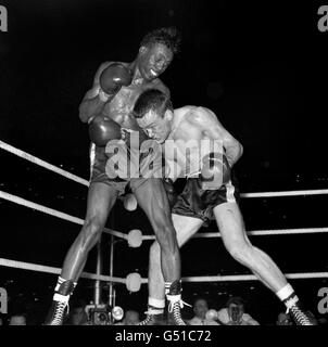 Der britische Herausforderer Dave Charnley (r) arbeitet während des Kampfes am Unterkörper des Amerikaners Joe Brown. Joe Brown gewann nach 15 Runden auf Punkte. Der Kampf wurde 1961 Ring Magazine Fight of the Year gewählt. Stockfoto