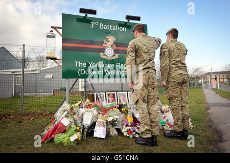 Die Soldaten grüßen, nachdem sie in der Kaserne des 3. Bataillons des Yorkshire Regiments in Warminster, Wiltshire, Bilder von Blumengebets platziert hatten, nachdem die sechs Soldaten bei dem einzigen schlimmsten feindlichen Angriff auf britische Truppen in Afghanistan seit Beginn der Operationen im Jahr 2001 getötet wurden. Stockfoto