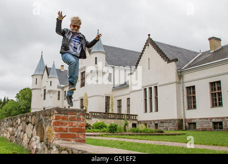 Junge springt vor Alatskivi Burg, in der Nähe von Peipussee, Estland Stockfoto