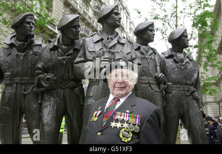 Bill Bourne, 78, der im Zweiten Weltkrieg in Nordafrika in Panzern diente, steht vor einer Bronzestatue einer fünfköpfigen Panzerbesatzung, die Queen Elizabeth II. Am Whitehall Place, London, enthüllt hat. * die Gedenkstatue ist den Männern des Königlichen Panzerregiments gewidmet, das vor 100 Jahren am 13/06/00 gegründet wurde. Die Königin wurde von einem Panzerwagen von Rolls-Royce aus dem Jahr 1924 vom Buckingham Palace zur Statue begleitet. Stockfoto