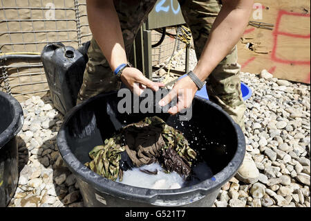 Soldaten waschen sich in der Patrol Base (PB) Clifton an der Spitze der Sefton Route, wo die geschäftige und abgelegene PB auf Patrouillen in den Osten häufige Feindkontakte sieht, wo die Taliban noch immer eine Festung auf der grünen Zone im Deh Adam Khan Bezirk der Provinz Helmand haben, Afghanistan. Stockfoto