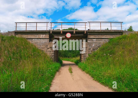 Eisenbahnbrücke über eine ländliche Schotterstraße Stockfoto