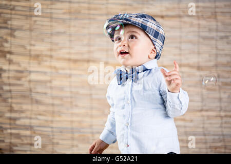 Baby Boy mit Gentleman-Outfit auf Bambus-Hintergrund Stockfoto