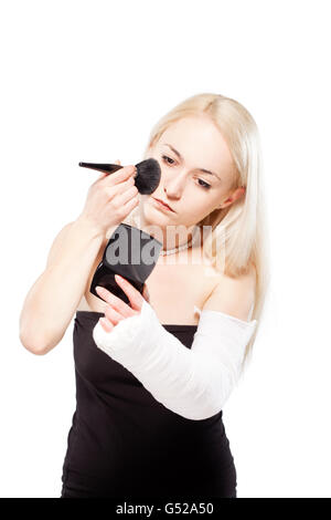 Blondes Mädchen mit einem gebrochenen Arm in Gips, die Probleme bei der Umsetzung eines Lippenstifts Stockfoto