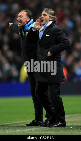 Roberto Mancini (Mitte), Manager von Manchester City, und erster Teamtrainer David Platt (links) ruft Befehle auf der Touchline Stockfoto