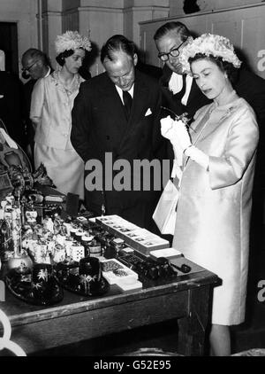 Königin Elizabeth II. Blickt genau auf ein Feuerzeug, als ihr Schmuggelware gezeigt wurde, die vor kurzem beschlagnahmt wurde, nachdem sie den restaurierten Ostflügel des Custom House in der Lower Thames Street, City of London, eröffnet hatte. Stockfoto