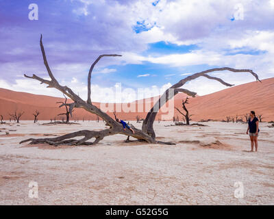 Namibia, Hardap, Sossusvlei, kleiner Junge entspannen Sie sich auf einen uralten Baum in der Wüste von Namibia Stockfoto