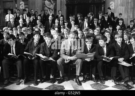 Benjamin Britten, in der ersten Reihe mit einem Teil des Wandsworth School Boy's Choir in St. Paul's Cathedral, als sie sein neuestes Werk "Children's Crusade", Op.82, einstudierten, eine Ballade für Kinderstimmen und Orchester. Die Arbeit wurde anlässlich des Jubiläums des „Save the Children Fund“ geschrieben. Es wird vom Chor der Wandsworth School Boy beim interkonfessionellen Thanksgiving Service des Fonds in der St. Paul's Cathedral und beim Aldeburgh Festival im Juni vom selben Chor gesungen. Die Worte entstammen dem Text des deutschen Dichters und Dramatikers Bertold Brecht und der Ballade Stockfoto