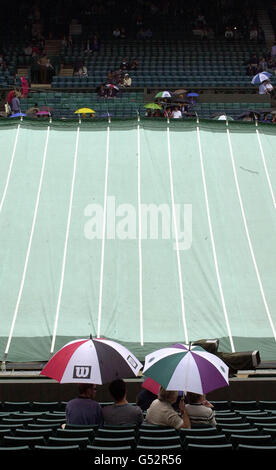 Keine kommerzielle Nutzung : Tennis-Fans sitzen unter ihren Sonnenschirmen auf Center Court in Wimbledon heute, Sonntag, 9. Juli 2000. American Pete Sampras wird im Finale der Herren-Singles gegen Pat Rafter aus Australien spielen. Stockfoto