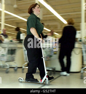 Die Geschäftsassistentin Lesley Dring schart im neuen Asda Walmart Supercenter nahe der M5 in Bristol durch. Der Laden ist der erste Asda-Walmart, der in Großbritannien eröffnet wird, und die Mitarbeiter werden mit Motorroller ausgestattet, um ihnen zu helfen, die riesige Ladenfläche zu erkunden. * die riesige US-Lebensmittelkette startet am 24. Juli nach einer Erweiterung und Umgestaltung eines bestehenden Asda-Hypermarktes in Bristol ihren riesigen Laden neben der M5. Manager haben beschlossen, die Roller an die "Läufer" des Stores auszustellen, deren Aufgabe es ist, über den 100,000 Quadratfuß großen Laden zu scamper, um Preise zu überprüfen und Produkte für Kunden auf der 46 auszutauschen Stockfoto