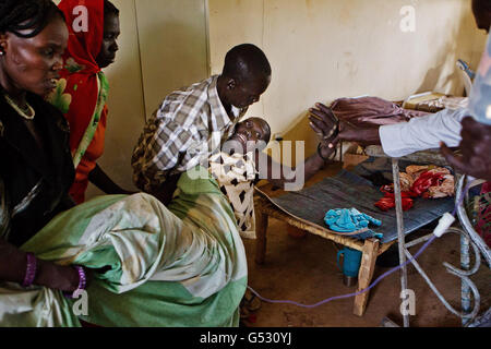 Verletzte Flüchtlinge und Soldaten in der gemeinsamen Klinik in Bunj, Maban, im Bundesstaat Upper Nile Blue Nile im Nordosten des Südsudans, Afrika. Die Region litt vor kurzem unter schweren Zusammenstößen zwischen Nord- und Südsudan, die Zehntausende von Menschen in Flüchtlingslager wie Doro und JamMan zwangen und Hunderte von Todesfällen durch die Bombardierung von Dörfern und Zusammenstöße zwischen rivalisierenden bewaffneten Gruppen zur Folge hatten. Stockfoto