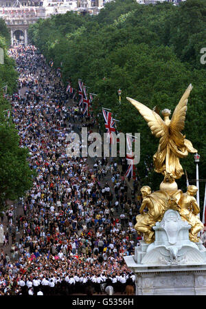 Die Menschenmassen gehen zum Queen Victoria Memorial in der Mall, London, um zuzusehen, wie Mitglieder der königlichen Familie auf dem Balkon des Buckingham Palace anlässlich der Feierlichkeiten zum 100. Geburtstag der Queen Mother auftreten. Die Queen Mother erhielt die traditionelle Geburtstagsnachricht von ihrer Tochter, Queen Elizabeth II, bevor sie mit ihrem ältesten Enkel, Prinz Charles, in einer offenen Kutsche zum Buckingham Palace fuhr. Stockfoto