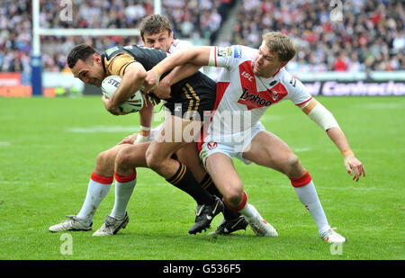 Wigans George Carmont wird von St. Helens Jon Wilkin (links) und Michael Shenton während des Stobart Super League-Spiels im Langtree Park, St. Helens, angegangen. Stockfoto