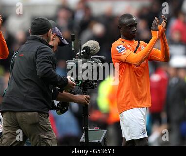 Fußball - Barclays Premier League - Swansea City / Newcastle United - Liberty Stadium. Papiss Cisse (rechts) von Newcastle United wird nach dem letzten Pfeifen von einem Fernsehteam begleitet. Stockfoto