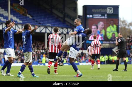 Leon Osman von Everton (Mitte) feiert das dritte Tor seiner Spielers Des Spiels mit Teamkollegen Magaye Gueye (19) Stockfoto