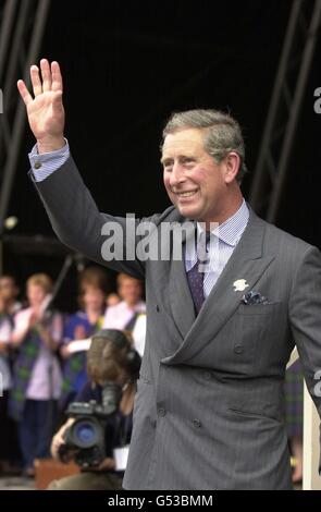 Prinz Charles winkt der Menschenmenge zu, während er sich in den Princes Street Gardens in Edinburgh während des BT Millennium Piping Festivals zur Unterstützung der Marie Curie Cancer Care Charity trifft. Stockfoto