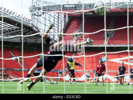 Der neue französische Torhüter von Manchester United, Fabien Barthez, taucht während eines Trainings vor dem Charity Shield Spiel gegen Chelsea am 13/8/00 auf einen Schuss von Stürmer Andy Cole. * der traditionelle Beginn der Fußballsaison. Stockfoto