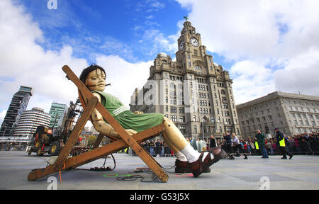 Der kleine Mädchengigant „macht ein Nickerchen“ vor dem Lebergebäude in Liverpool. Stockfoto