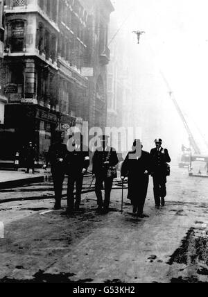 Premierminister Winston Churchill (zweiter von rechts) während einer Tour durch die Schäden, die durch einen nächtlichen Luftangriff auf Cheapside am St. Mary-le-Bow im Zentrum von London während des Zweiten Weltkriegs verursacht wurden. Stockfoto