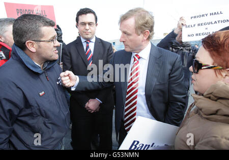 Taoiseach Enda Kenny spricht heute mit Darren Kelly, dem ehemaligen Bewohner der Priory Hall, auf seinem Weg in die Stellenanzeige von Mylan in Baldoyle in Dublin. Stockfoto