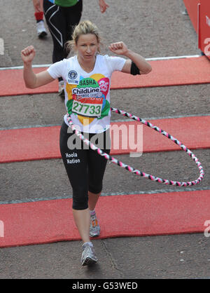 Leichtathletik - 32. Virgin London Marathon. Beim 32. Virgin London Marathon in London erreicht ein Läufer den Weltrekord beim Drehen eines Hoola-Hoops. Stockfoto