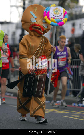 Ein Wettkämpfer mit ausgefallenen Kleidern beim 32. Virgin London Marathon in London. Stockfoto