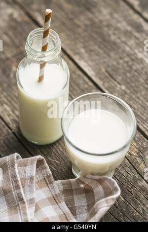 Frische Milch in Glasflasche mit Stroh. Stockfoto