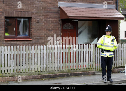 Ein Polizist steht vor einem Haus am Cheriton Drive, Bolton, Greater Manchester. Stockfoto