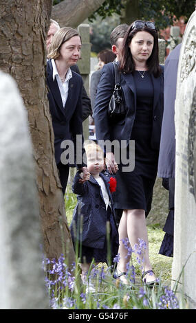 Natalie (rechts), die Witwe von Sergeant Nigel Coupe, kommt zu seiner Beerdigung in der St. Anne's Parish Church, Lytham St Annes, Lancashire, und hält die Hand ihrer Tochter Jasmine Stockfoto