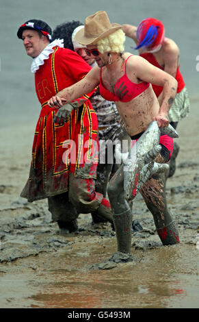 FOTOGRAFIEREN Sie die Teilnehmer im Schlamm, während sie am jährlichen Maldon Mud Race teilnehmen, auf dem Fluss Blackwater in Maldon Essex. Stockfoto