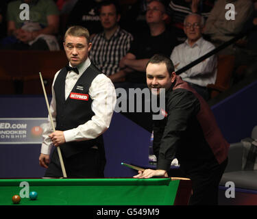 Der schottische Stephen Maguire am Tisch mit dem schottischen Stephen Hendry (links) während der Snookerweltmeisterschaften Betfred.com im Crucible Theatre, Sheffield. Stockfoto